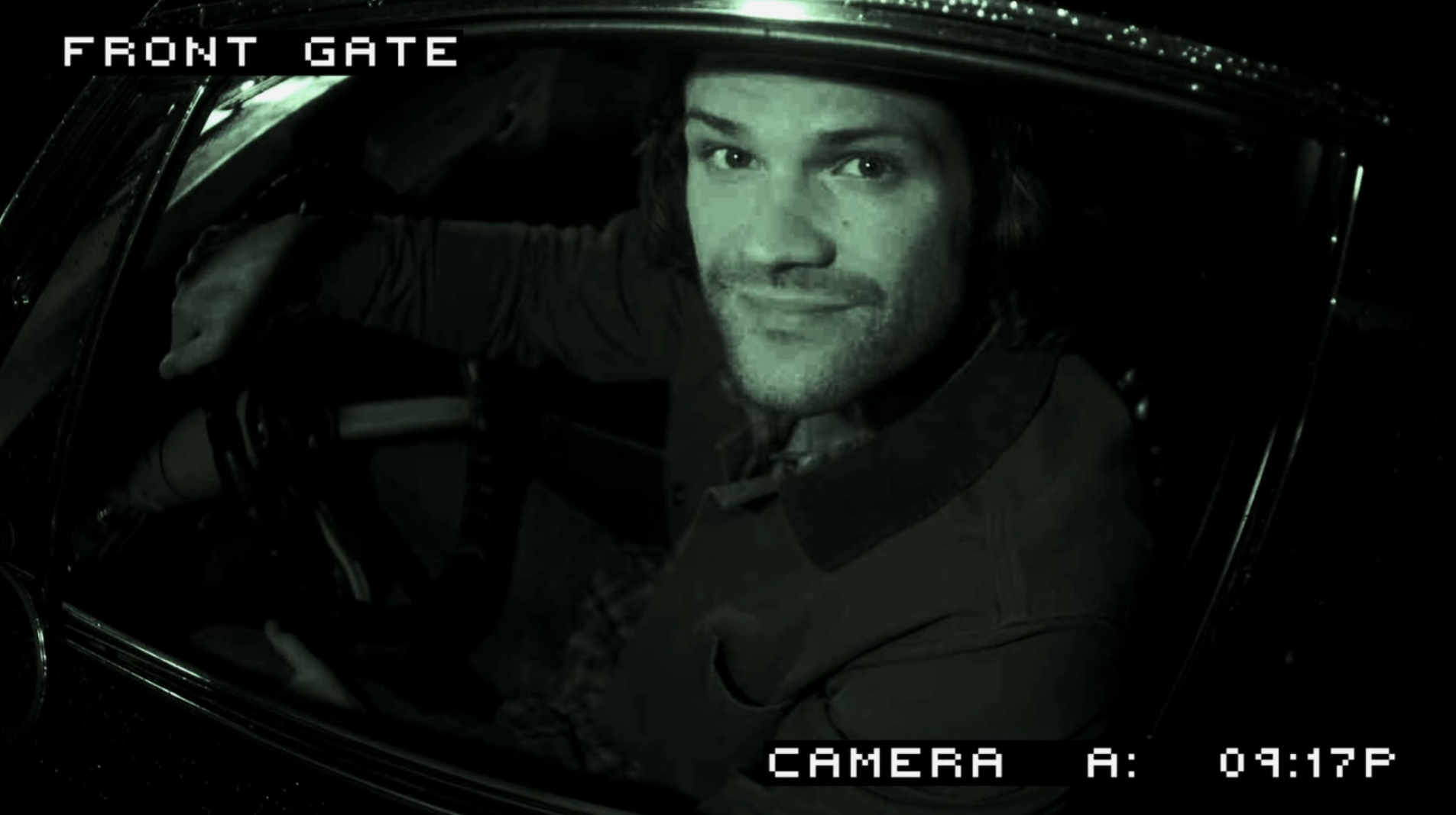 sam winchester looking through a car window and directly into a security camera